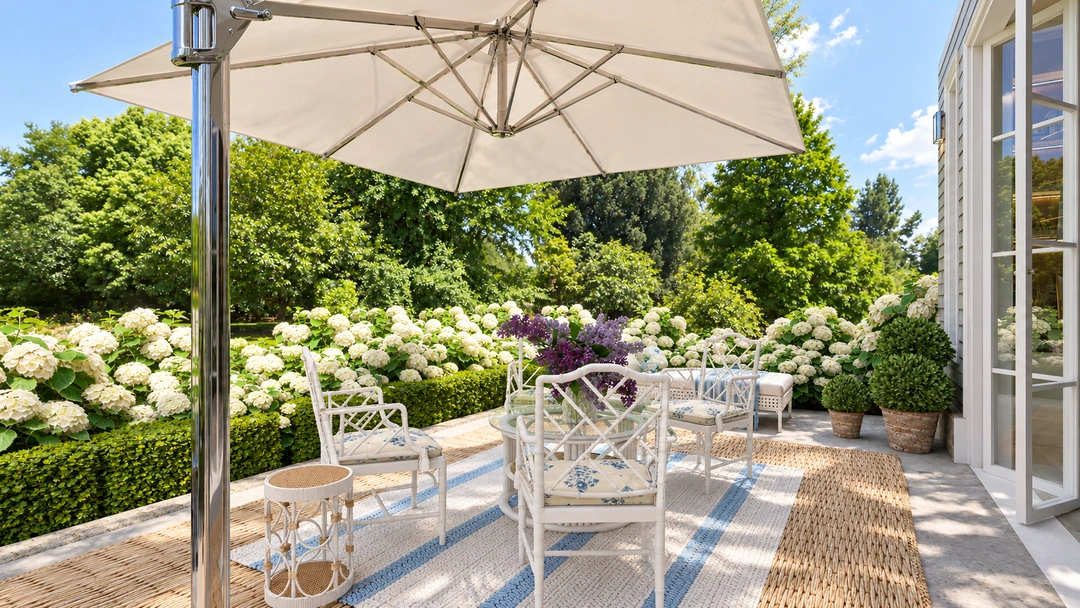 Outdoor dining table beneath umbrella among flowering plants — Wilmington, NC, Studio Dalika; project view 12